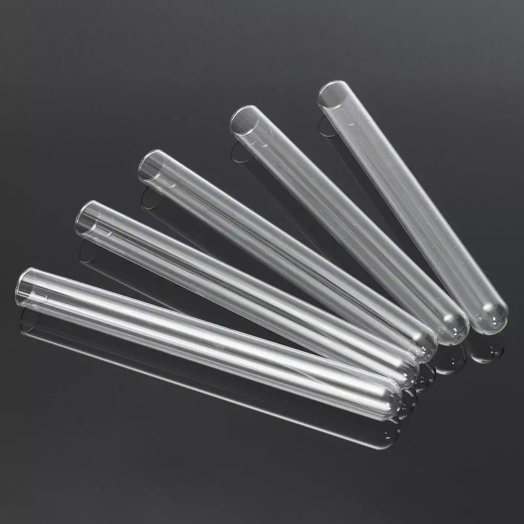 Five empty glass test tubes arranged diagonally on a reflective surface