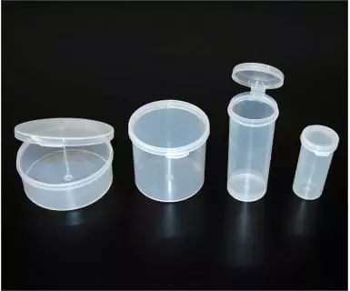 Four translucent plastic containers with hinged lids on a dark background